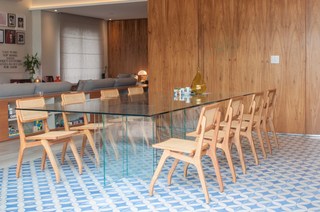 6 tipos de materiais de tampo de mesa para salas de jantar e áreas gourmet. Projeto de Paiva e Passarini Arquitetura. Na foto, piso de ladrilhos azuis, mesa com tampo de vidro.
