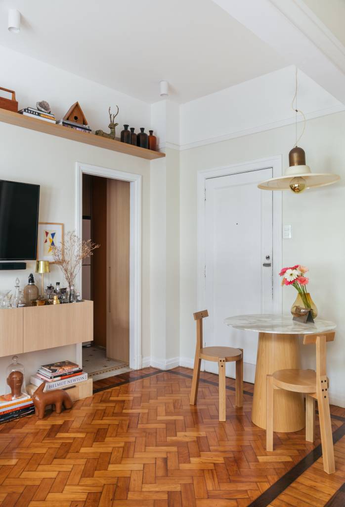 Apê de 42 m² em tons de branco e bege tem sala e quarto integrados. Projeto de Rodolfo Consoli. Na foto, sala, mesa de jantar redonda para dois lugares.