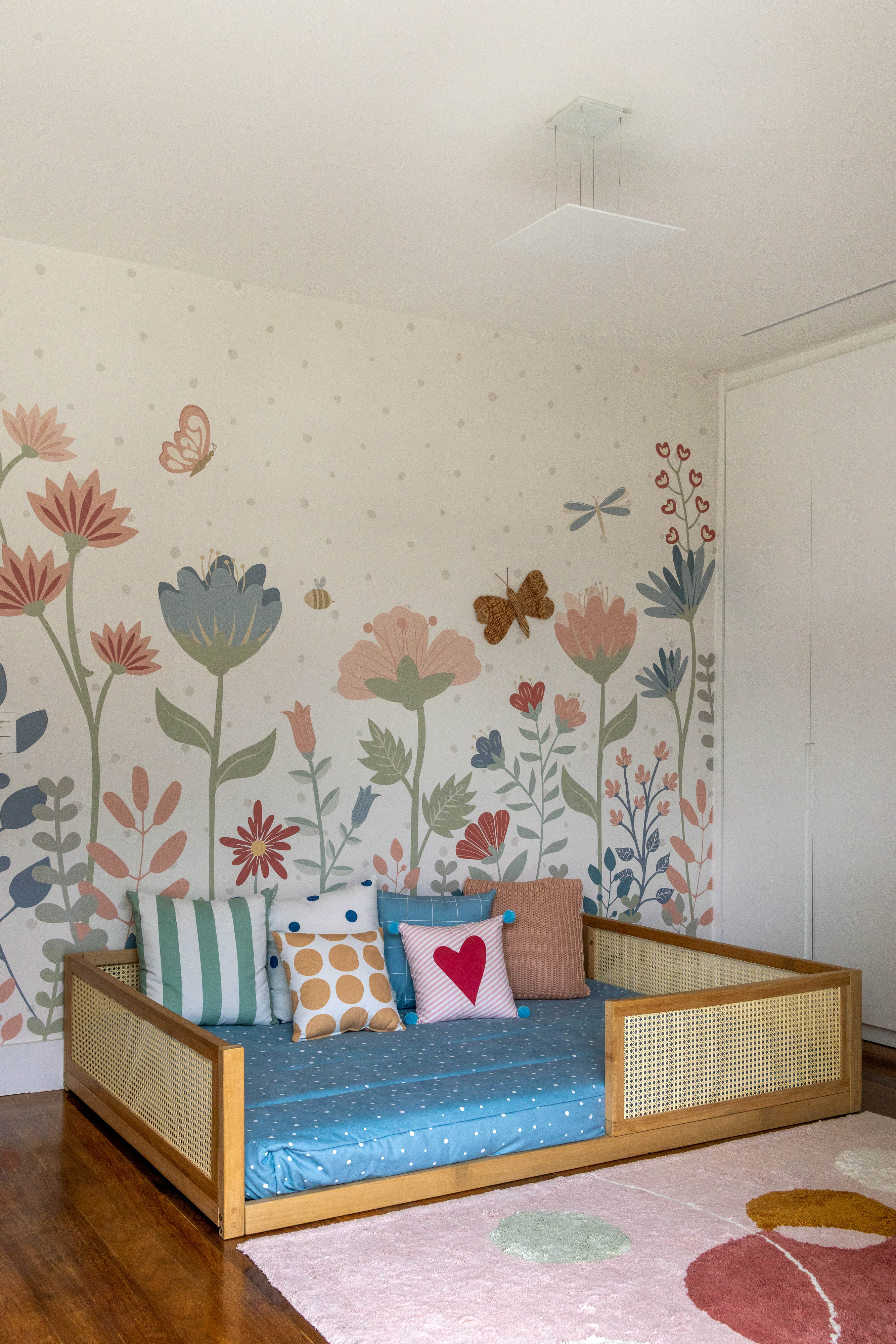 Azulejos pintados à mão com estampas botânicas revestem varanda de apê. Projeto de Renata Lemos. Na foto, quarto infantil, papel de parede floral, cama montessoriana.