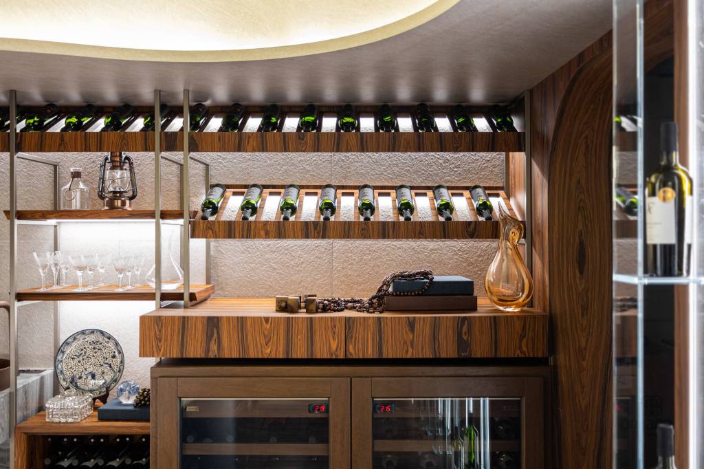CASACOR Paraná: espaço exclusivo celebra o vinho com adega residencial. Projeto de Janaina Marques e Camila Kubota. Na foto, adega residencial com mobiliário que destaca rótulos de vinho