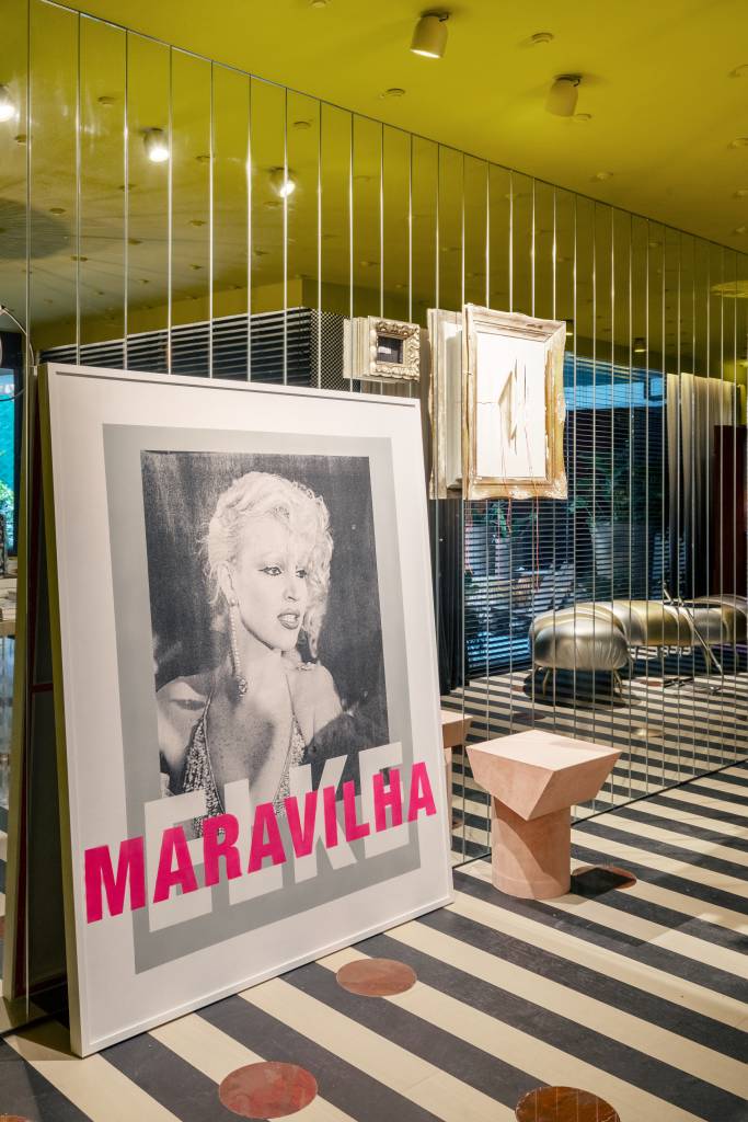 CASACOR São Paulo: hall maximalista tem parede espelhada e piso listrado. Projeto de Gustavo Scaramella. Na foto, hall com obras de arte encostadas em parede espelhada