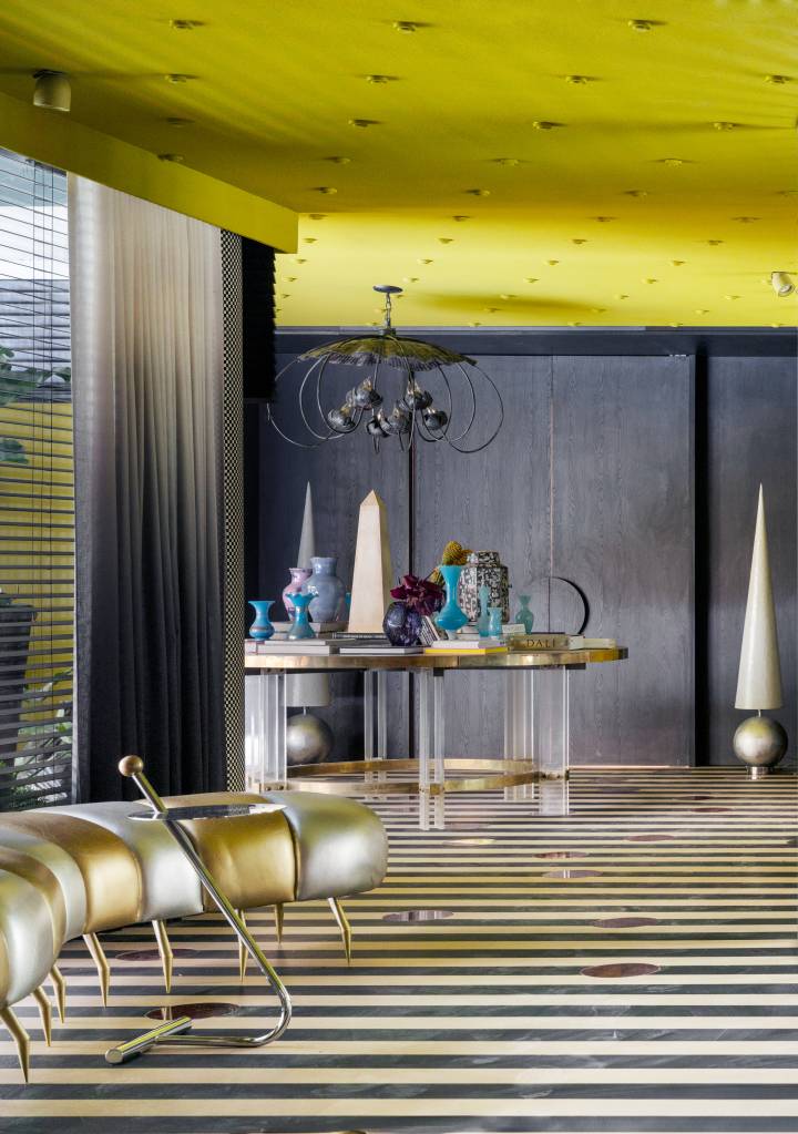 CASACOR São Paulo: hall maximalista tem parede espelhada e piso listrado. Projeto de Gustavo Scaramella. Na foto, hall com piso listrado e móveis de diferentes estilos
