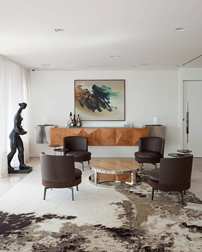 Cores naturais: veja quais são os tons mais populares com projetos e dicas. Projeto de Korman Arquitetos. Na foto, sala de estar, poltronas marrons, tapete animal print de vaca.