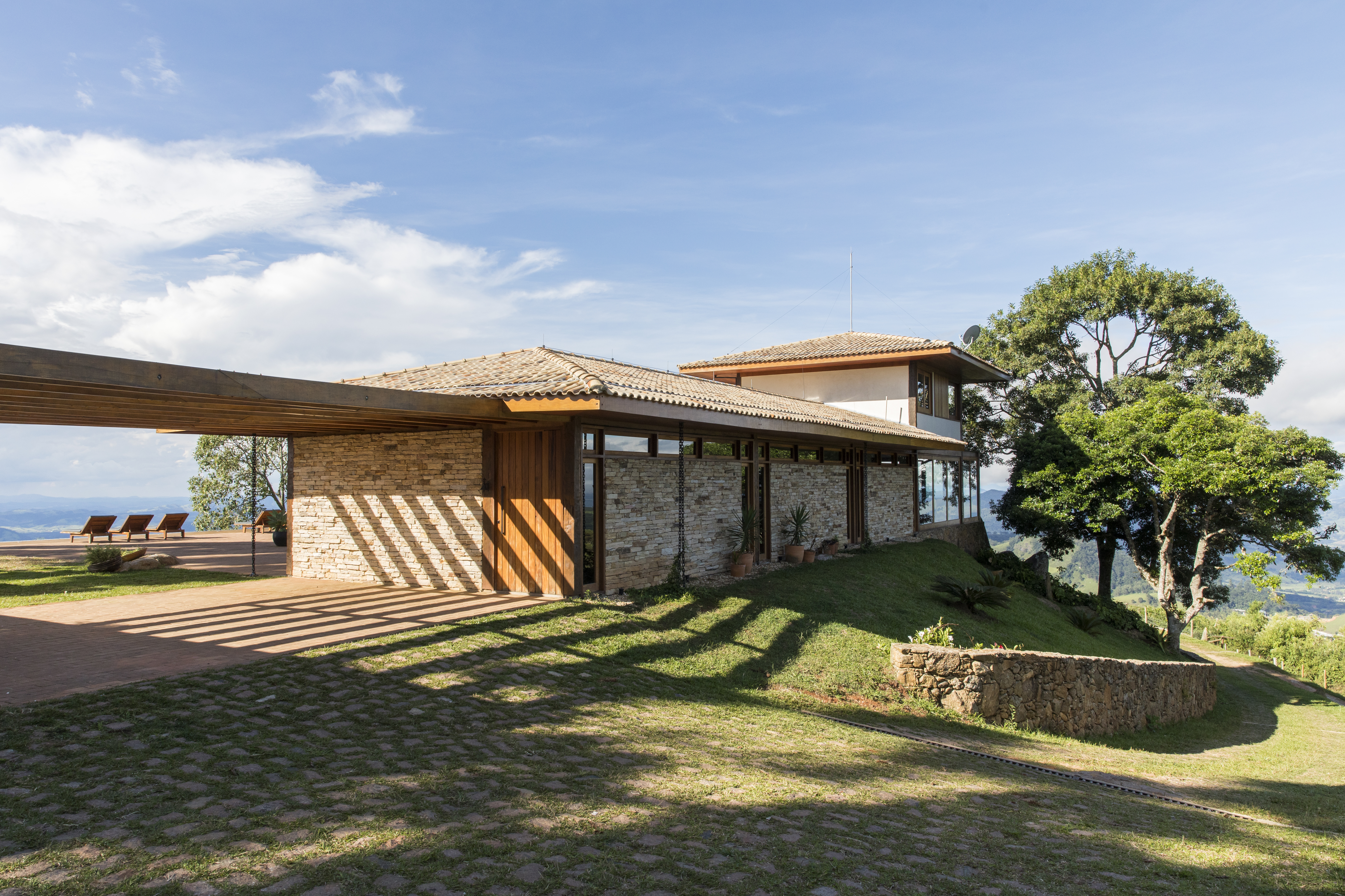 Linda casa na montanha tem lareira e cozinha rústica com fogão à lenha. Projeto de Sabella Arquitetura. Na foto, fachada de casa.