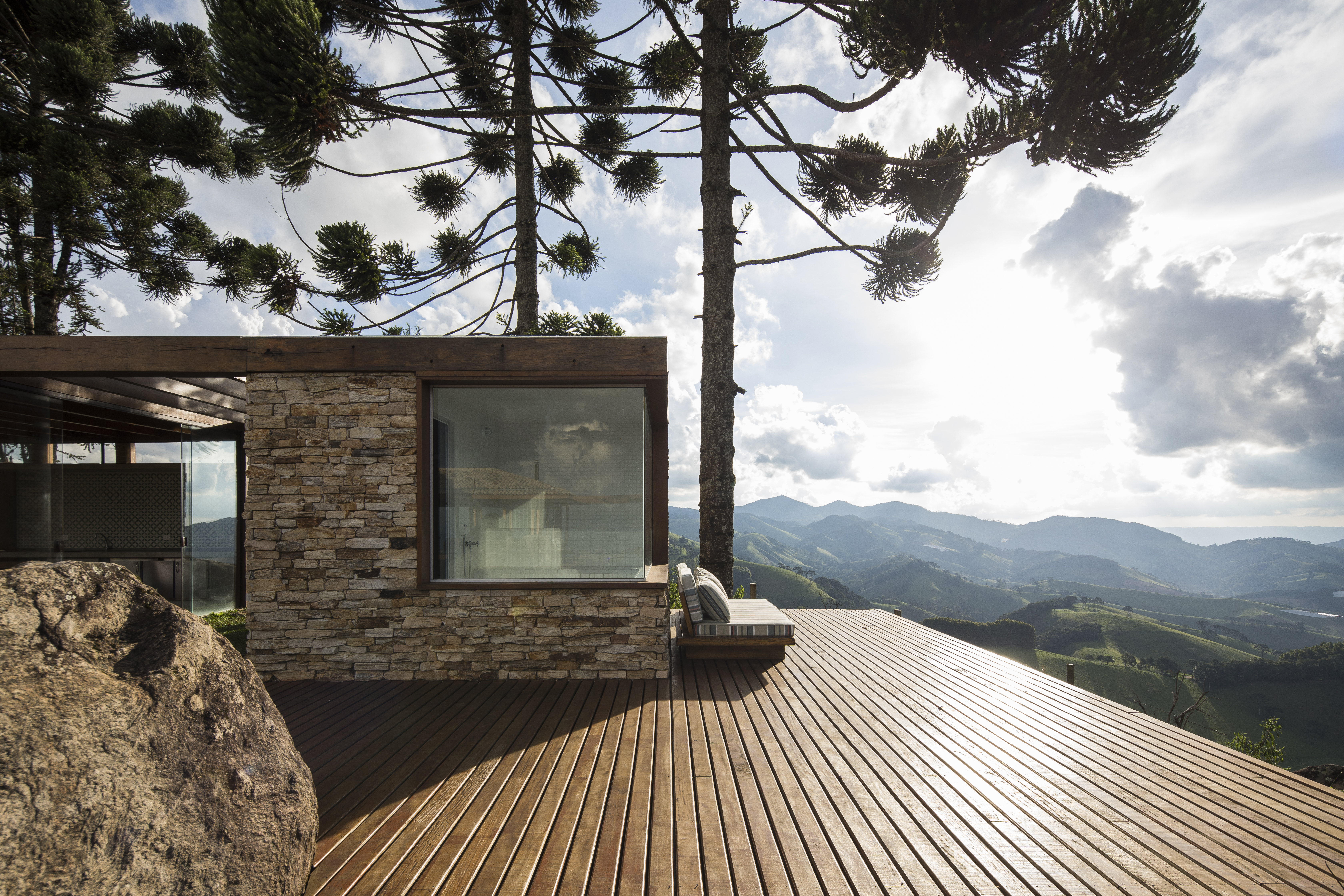 Linda casa na montanha tem lareira e cozinha rústica com fogão à lenha. Projeto de Sabella Arquitetura. Na foto, varanda, deck, vista.