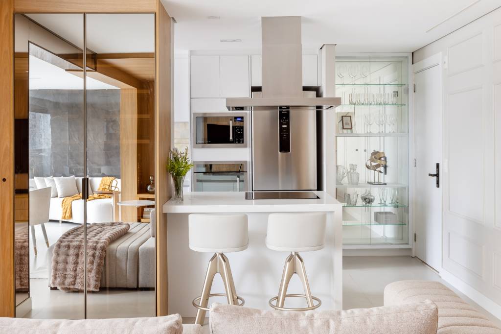 Painel de mármore traz elegância à apê com adega climatizada e cristaleira