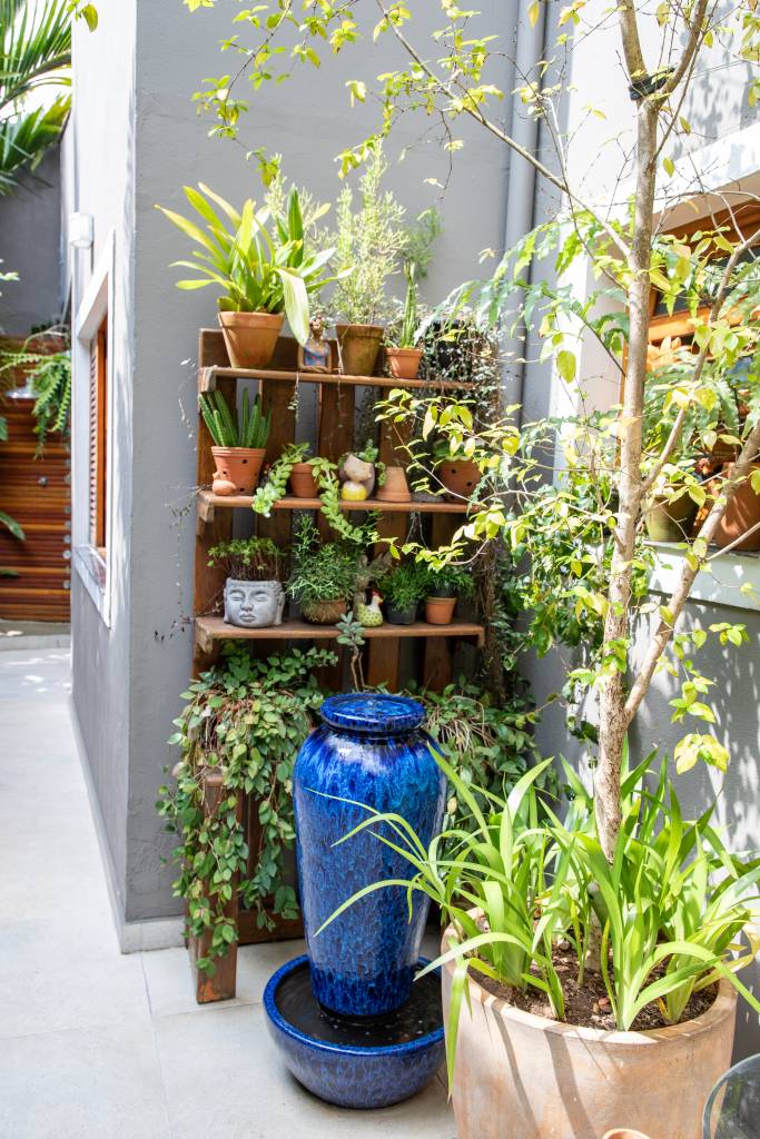 Palmeiras, dracenas, marantas e pacovás compõem esse jardim exuberante. Projeto de Marcilene Monzani Paisagismo. Vasos em prateleira.