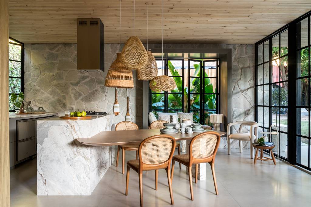 Pedras e vegetação em abundância marcam a estética orgânica deste loft. Projeto de Maria Alice Crippa e Gustavo Assis. Na foto, cozinha e área de convívio integradas