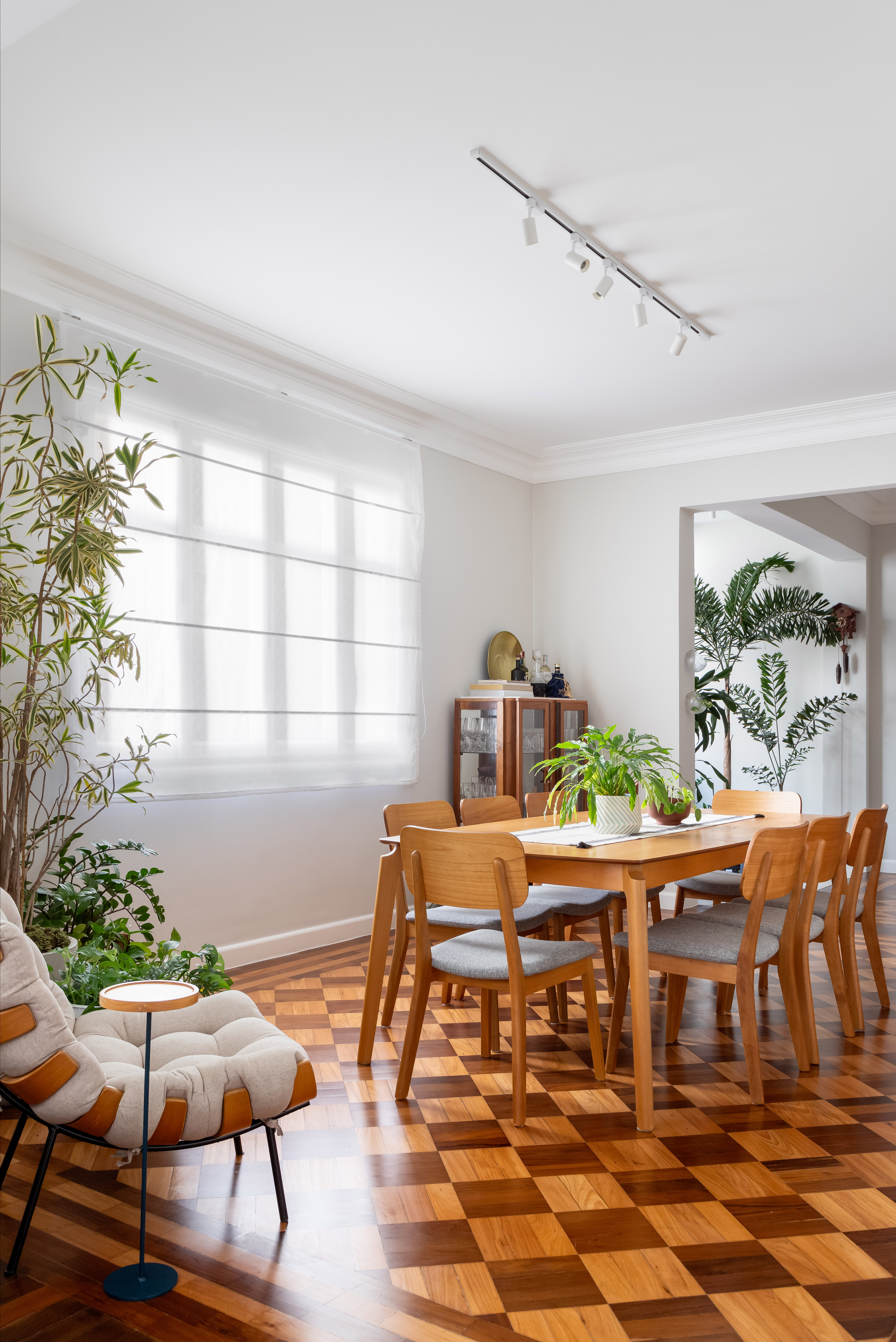 Piso de taco, janelas brancas e sancas dão charme parisiense a este apê. Projeto de Ana Paula Crivelenti. Na foto, sala de estar, mesa grande de madeira.