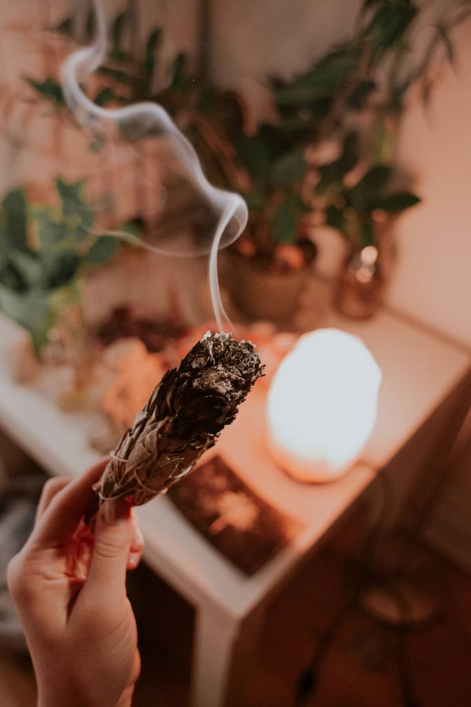 rituais-faceis-afastar-inveja-e-energia-negativa-visitas-marcos-paulo-prado-unsplash Rituais fáceis para afastar a inveja e a energia negativa de visitas. Na foto, cristal, mão queimando palo santo.