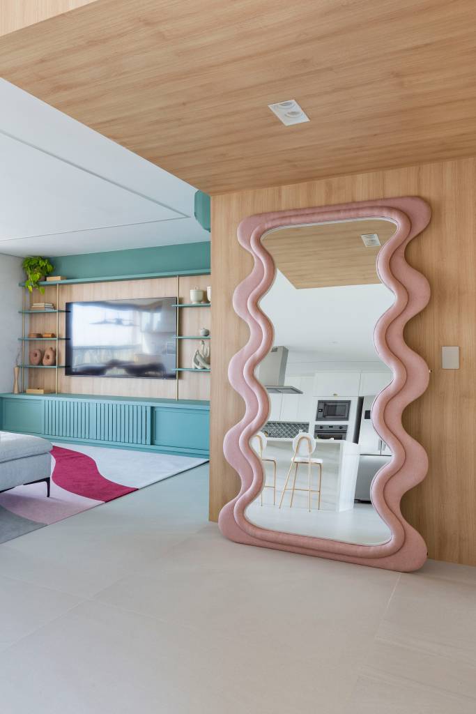 Arquiteta explica o estilo kitsch, tendência maximalista que viraliza nas redes! Projeto de Mari Milani. Na foto, sala de estar, espelho de piso grande com moldura rosa.