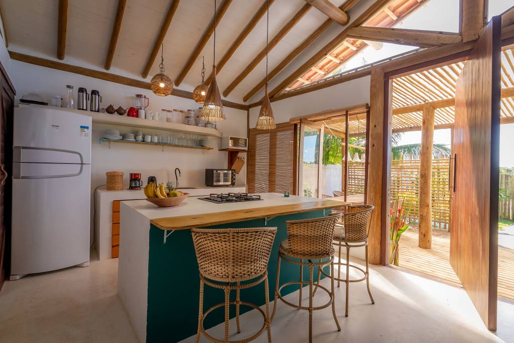 Casa pátio de praia na Bahia foi erguida em torno das árvores. Projeto de Mari Grobério. Na foto, cozinha com ilha.
