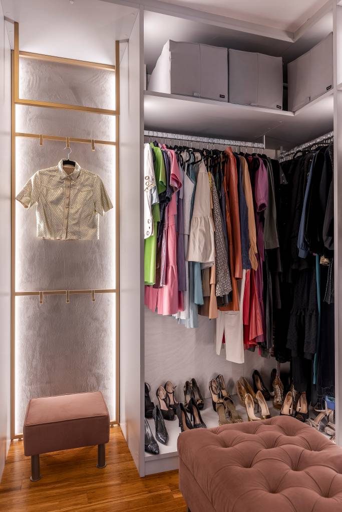 Closet sem portas e com iluminação interna é protagonista em suíte de apê. Projeto de Spaço Interior. Na foto, guarda roupa aberto iluminado.