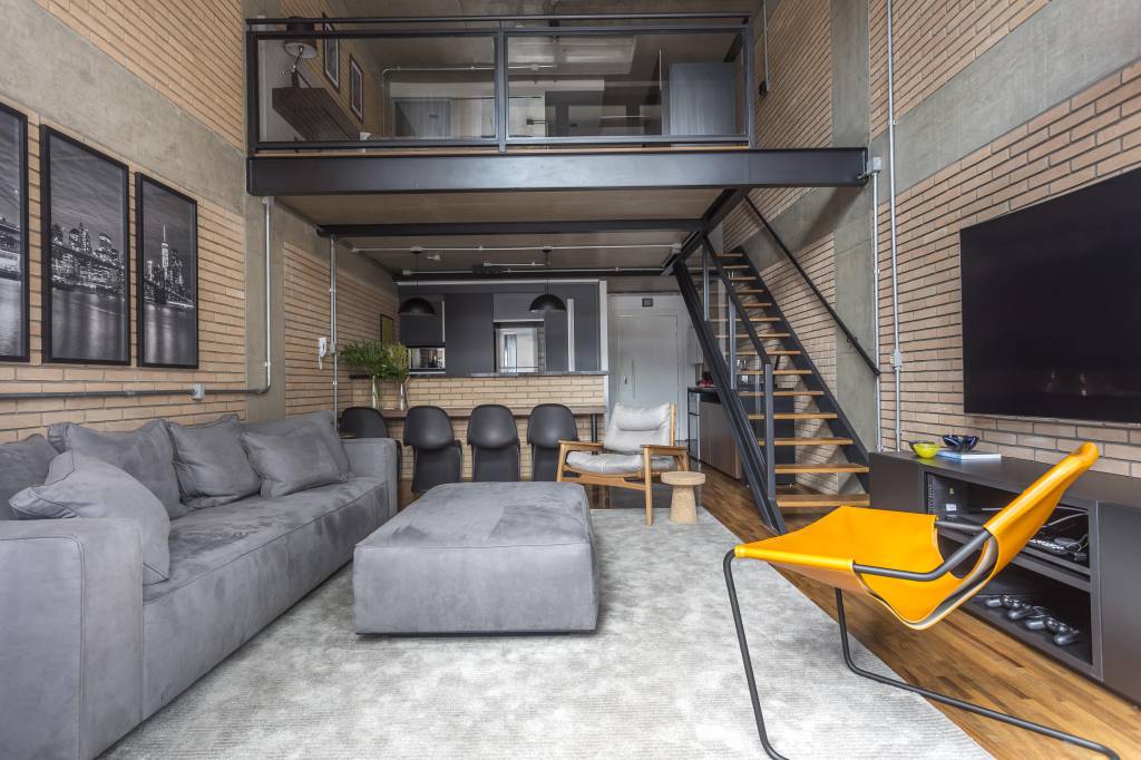 Como escolher e decorar lofts? Projeto de Korman Arquitetos. Na foto, loft em estilo industrial com decoração cinza e preta