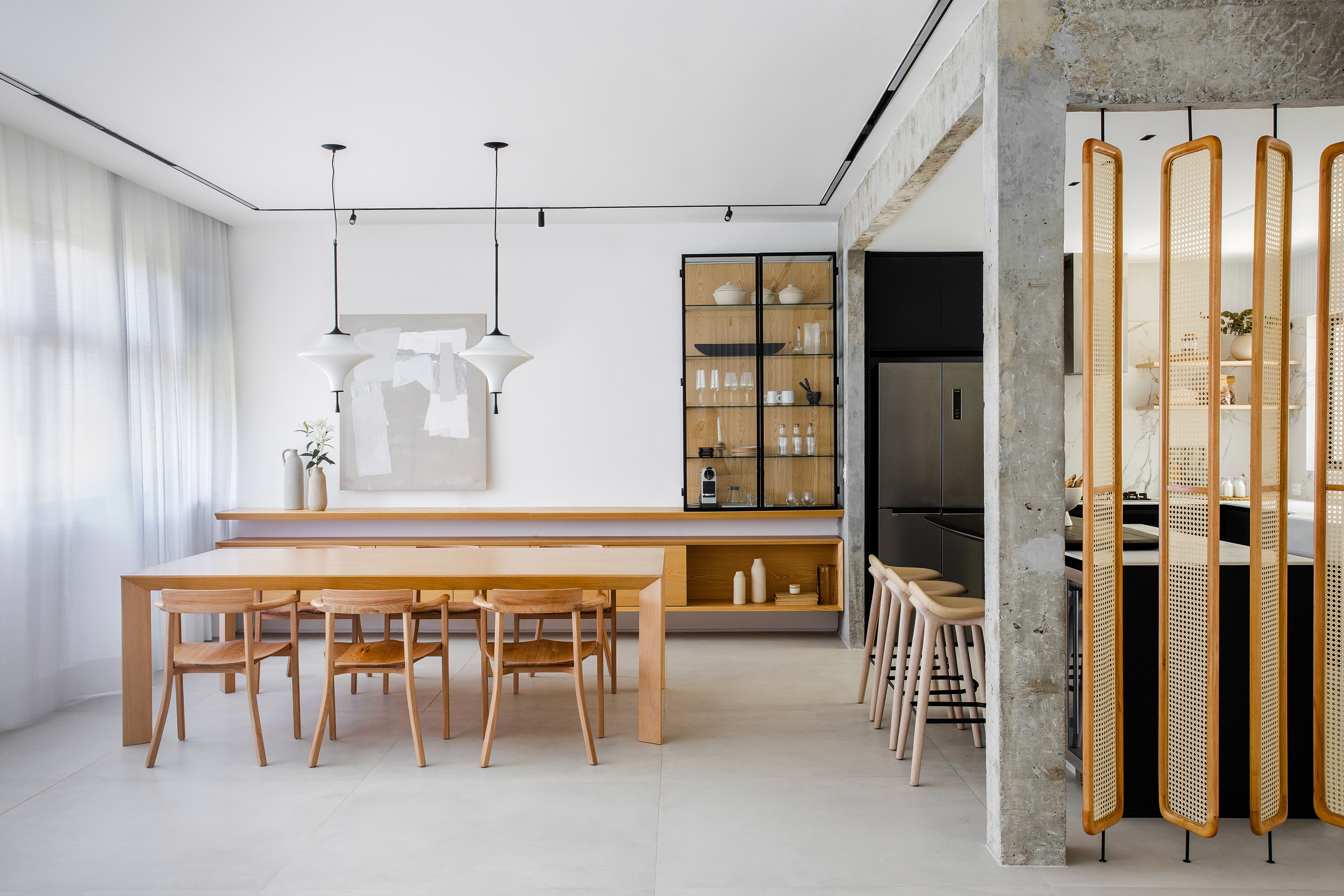 Cozinha preta e branca de apê minimalista tem brises arredondados com palhinha. Projeto de Natália Lemos. Na foto, sala de jantar, mesa de madeira, cristaleira.