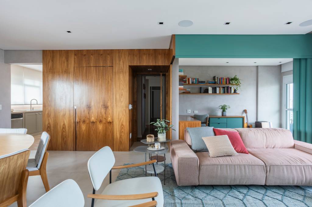 reforma-quarto-home-office-porta-de-correr-verde-adriana-favano-arquitetura-08 Reforma transforma quarto em home office e o integra a sala com porta de correr verde. Projeto de Adriana Favaro Arquitetura. Na foto, sala de estar, sofá rosa claro queimado, tapete azul, poltronas brancas.