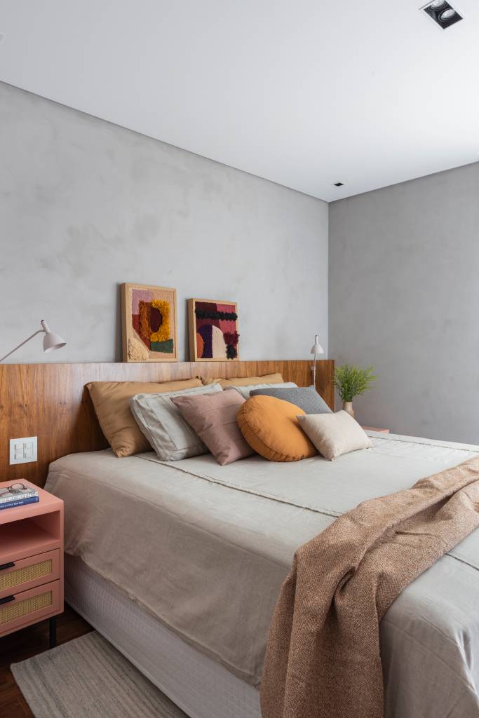 Reforma transforma quarto em home office e o integra a sala com porta de correr verde. Projeto de Adriana Favaro Arquitetura. Na foto, quarto de casal, cabeceira de marcenaria, parede em tom cimento queimado.