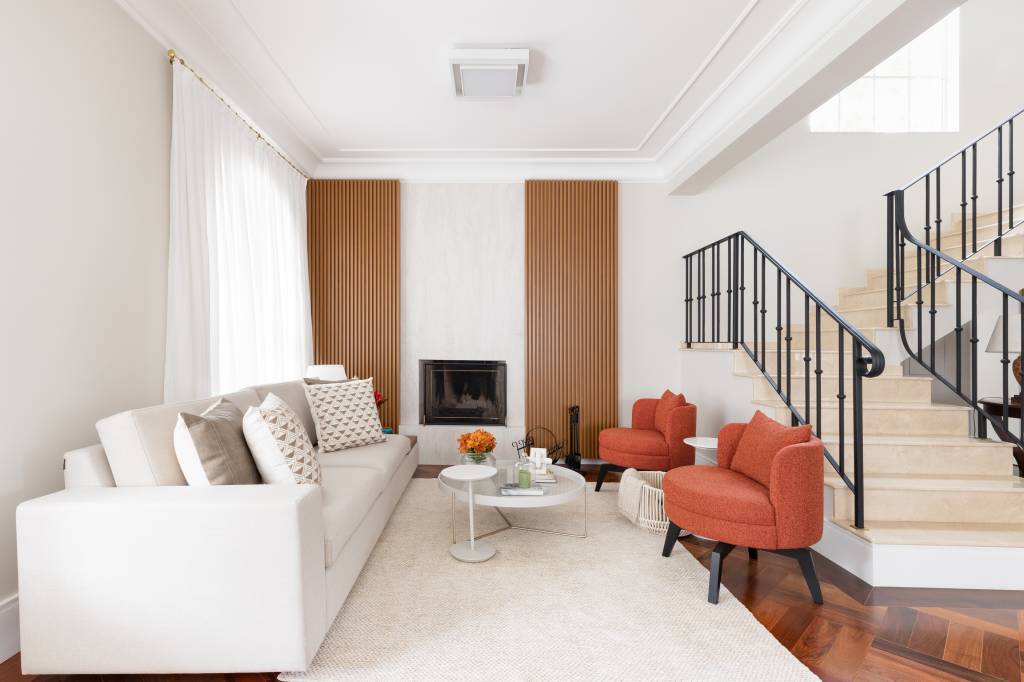 Retrofit em casa recupera parede ripada que emoldura lareira do living