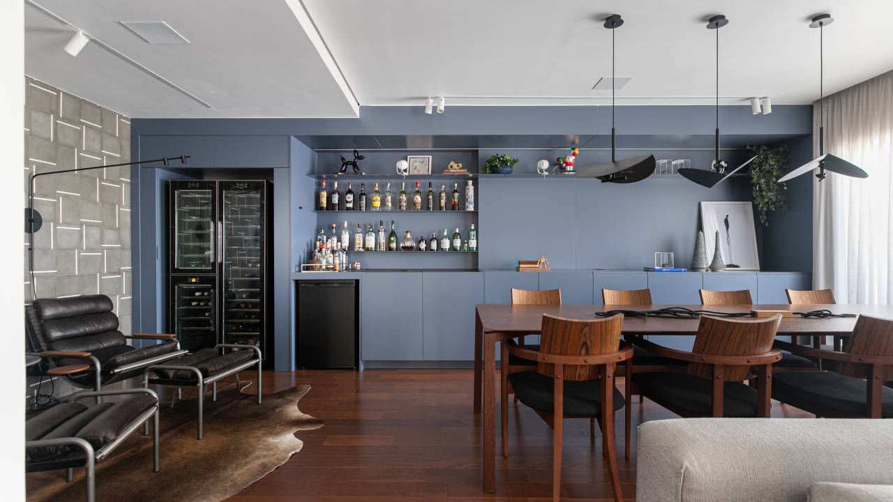 Apartamento de arquiteta tem paleta sóbria com toques de azul e verde e academia. Projeto de Natalia Salla. Na foto, sala de jantar, móvel de marcenaria azul.