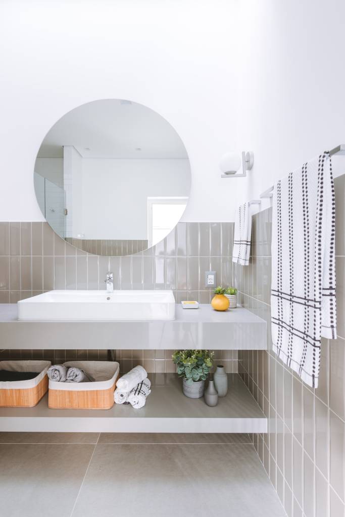 Cozinha azul e beliche em color block são destaque em casa de praia. Projeto de Rawi Arquitetura + Design. Na foto, banheiro, meia parede de azulejos na cor greige.