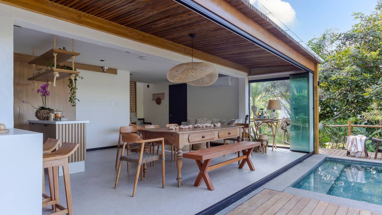 Estilo natural ganha estética refinada nesta linda casa de praia. Projeto de Juliana Zappa. Na foto, área gourmet, deck com piscina.