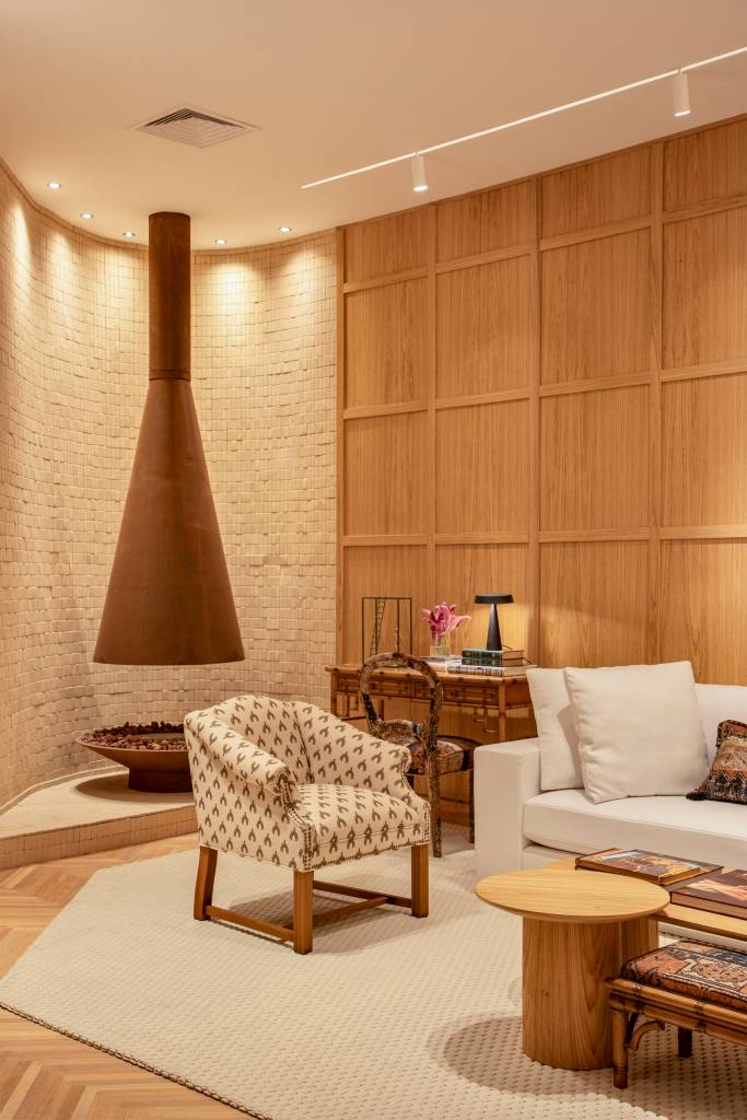 Marcenaria e divisórias vazadas setorizam espaços neste loft da CASACOR Rio. Projeto de Jacira Pinheiro. Na foto, sala, lareira.