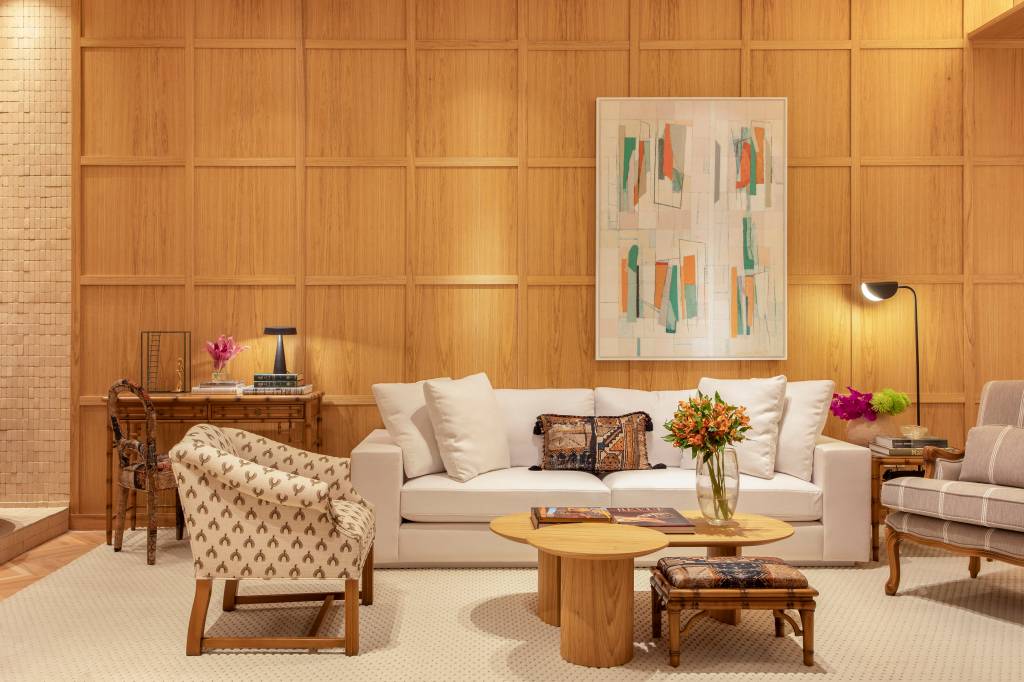 Marcenaria e divisórias vazadas setorizam espaços neste loft da CASACOR Rio. Projeto de Jacira Pinheiro. Na foto, sala, poltrona, sofá branco.