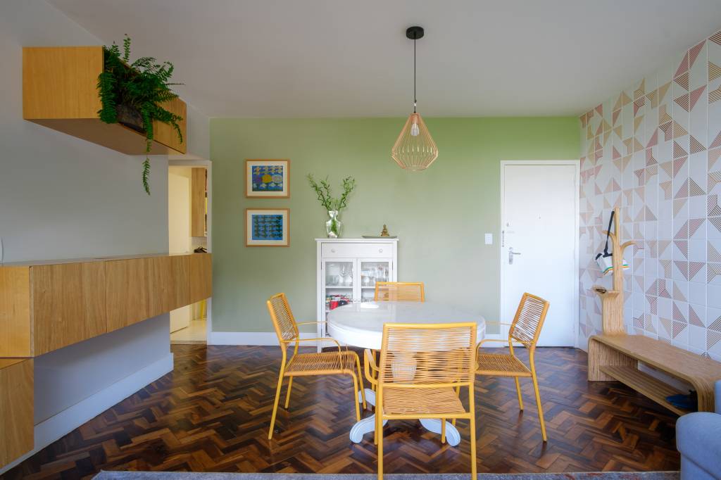 Módulos de marcenaria são estante, buffet, aparador e porta brinquedos. Projeto de Hersen Mendes Arquitetura. Na foto, mesa redonda, sala de jantar, parede de azulejos.