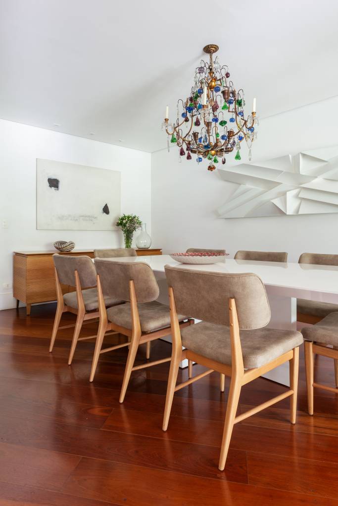 Piso de taco: veja tipos de madeira e dicas para consertar tacos soltos e riscos. Projeto de Dantas & Passos Arquitetura. Na foto, sala de jantar, mesa branca.