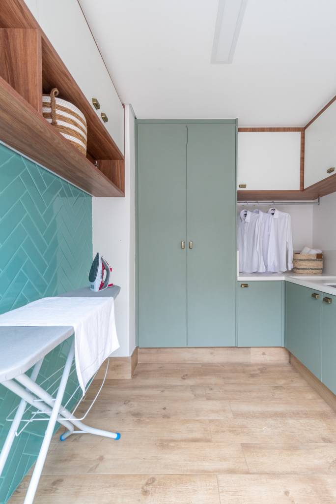 6 pontos que devem ser considerados para uma lavanderia prática e organizada. Projeto de Isabella Nalon. Na foto, área de serviço, tábua de passar roupa, parede de azulejos azuis.