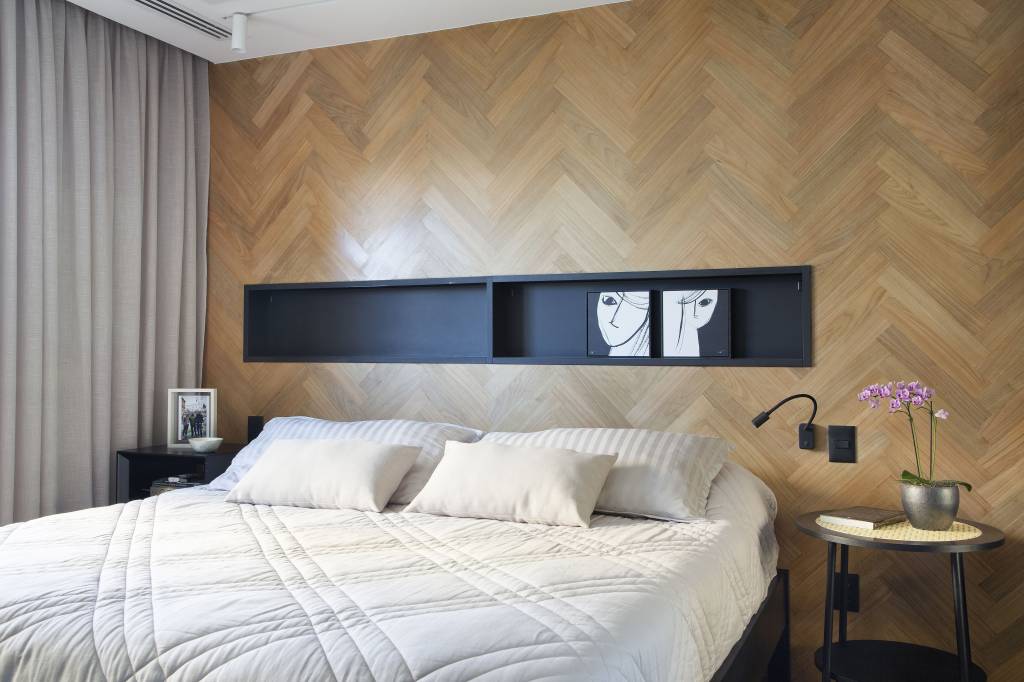 Quartos de serviço é transformado em copa de cozinha neste apê de 165 m². Projeto de designer de interiores Roberta Nicolau. Na foto, quarto, painel de madeira atrás de cama, nicho preto.