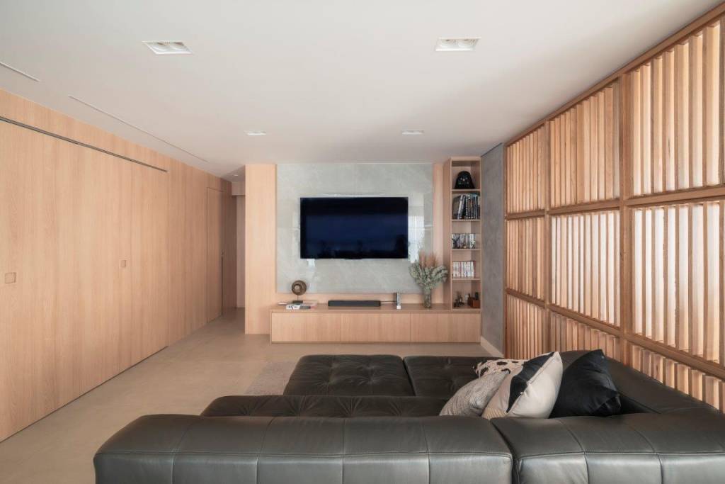 Brises de madeira delimitam sala de TV e jantar neste living sofisticado