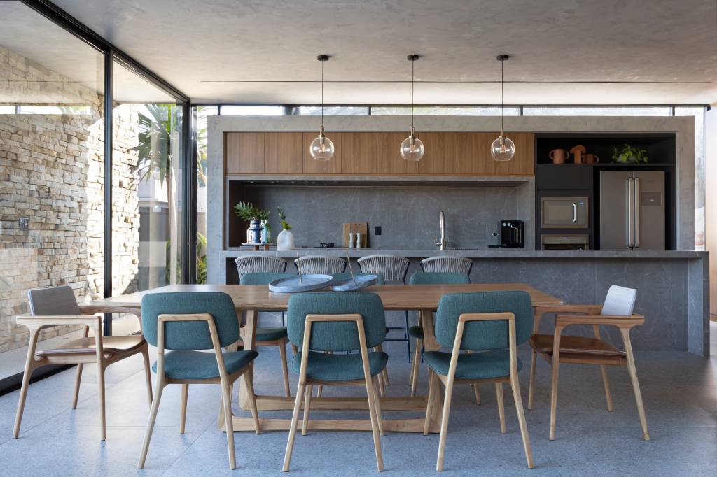 Casa de 344 m² destaca varanda gourmet com teto em cimento queimado, de Teto Arquitetura. Na foto, área gourmet com mesa de jantar.