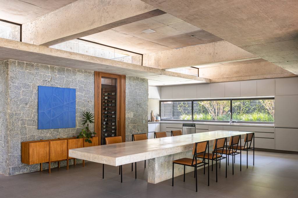 Concreto aparente marca estrutura de casa térrea com planta em formato L. Projeto de BLOCO Arquitetos.