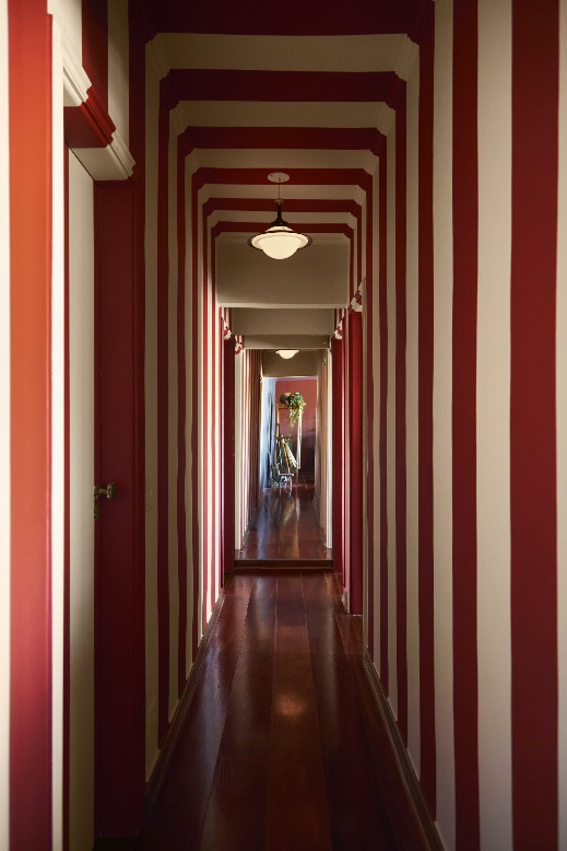 Decorações assustadoras! Veja projetos com cores inspiradas no Halloween. Na foto, corredor listrado vermelho e branco.