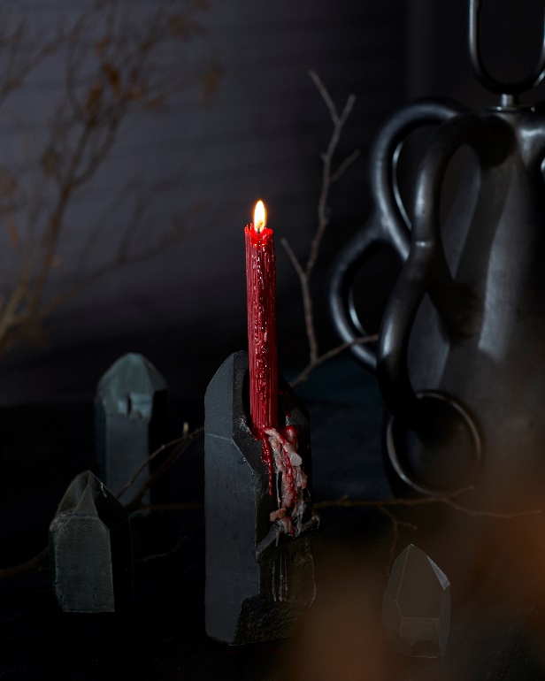 Decorações assustadoras! Veja projetos com cores inspiradas no Halloween. Na foto, sala de estar preta, vela vermelha.