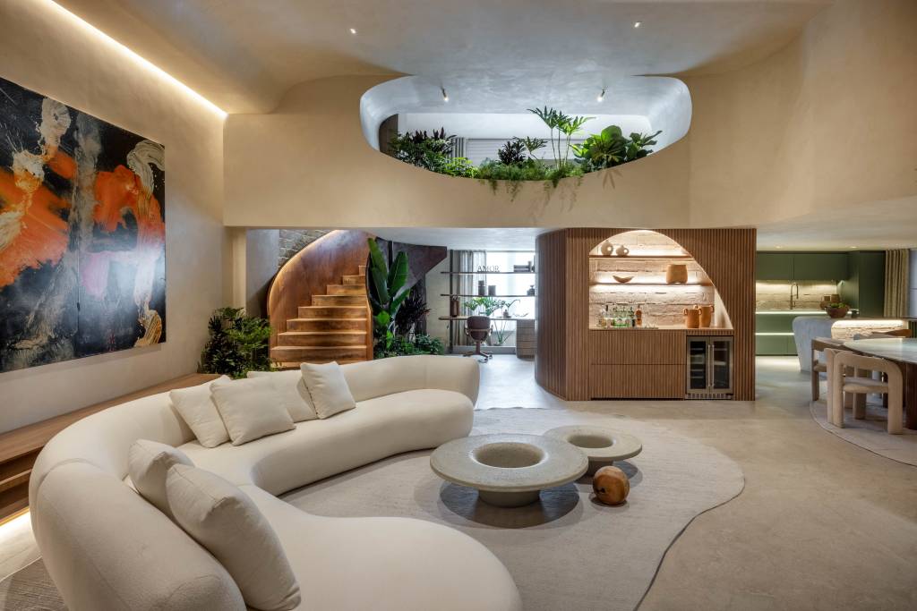 Loft com dois andares tem paleta de tons arenosos, verdes e marrons