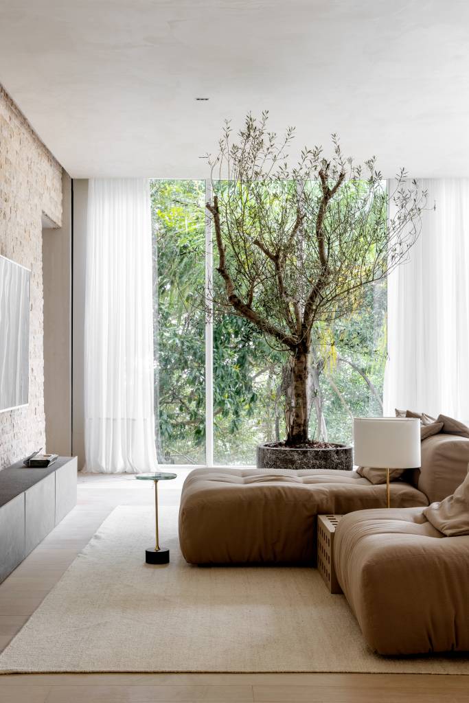 Loft reflete sobre o tempo com a presença de árvores, pedras e texturas naturais. Projeto de Mariana Maisonnave para a CASACOR SC 2024.