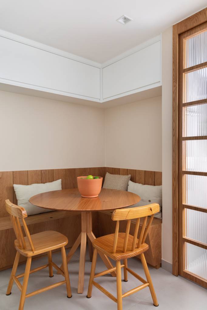 Madeira e palhinha marcam presença nos móveis e marcenaria de apê de 100 m². Projeto de Co+Lab Juntos Arquitetura. Na foto, copa de cozinha, canto alemão.