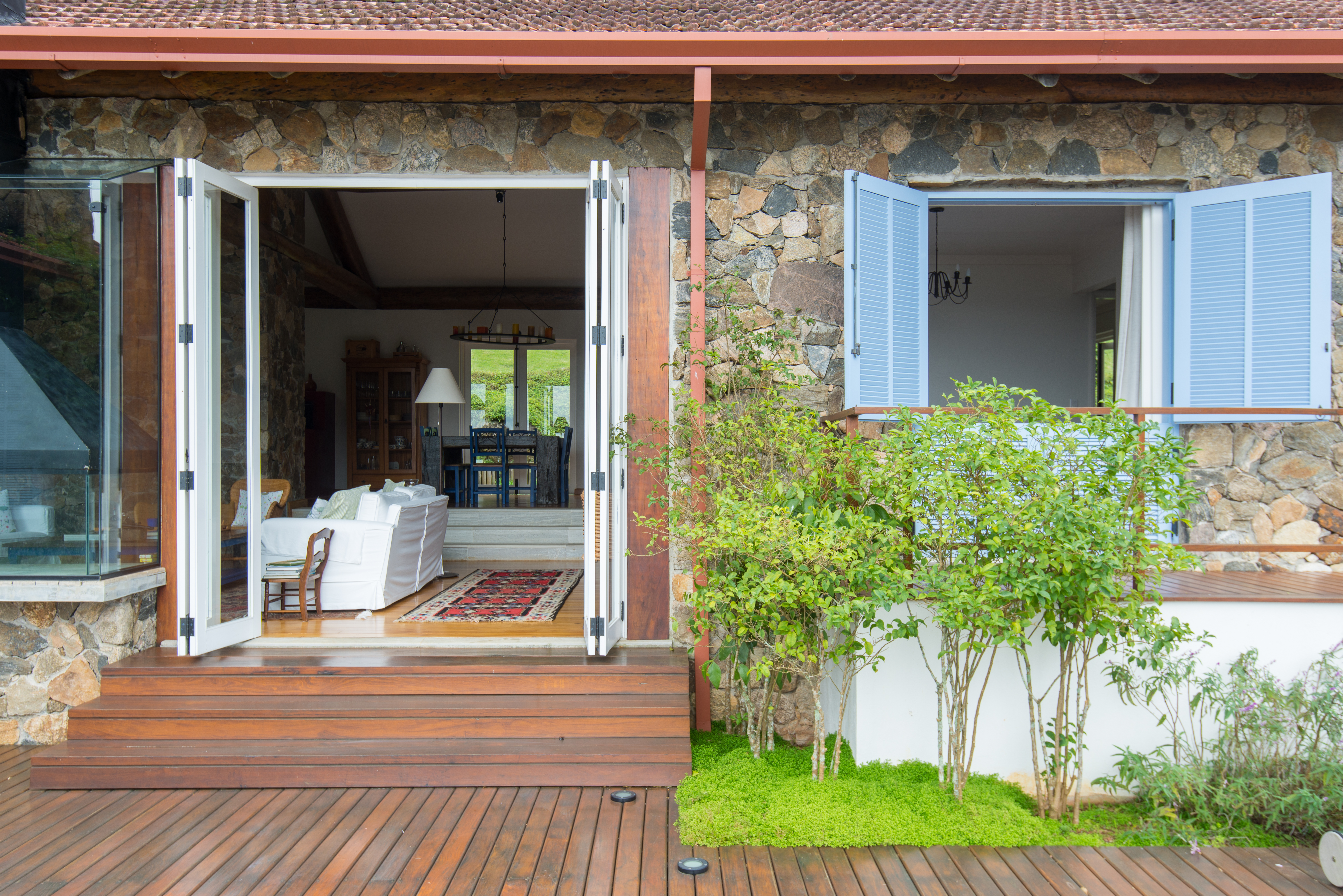 Paredes de pedra e lareira dão charme à casa de campo sustentável. Projeto de Falchi Arquitetura.