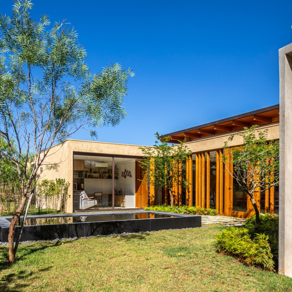 Vidro e brises de madeira conectam casa com 7 suítes com a natureza. Projeto de Gilda Meirelles Arquitetura.