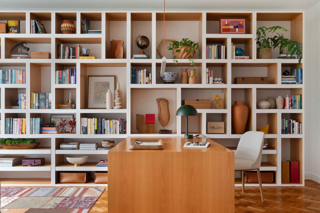 Biblioteca em casa: apê de 200 m² ganha espaço integrado para leitura. Projeto de Maria Juliana Galvão e Alexia Carvalho. Na foto, estante cheia de nichos.