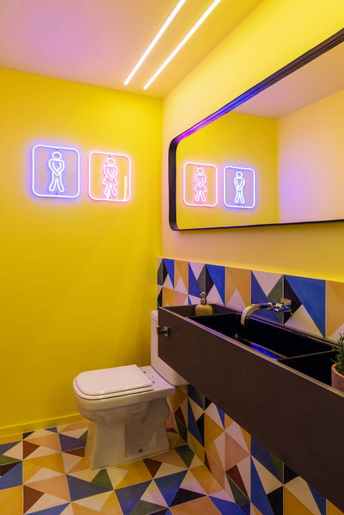 Apê divertido ganha área de pole dance e lavabo colorido. Projeto de TT Interiores. Na foto, banheiro, neon.