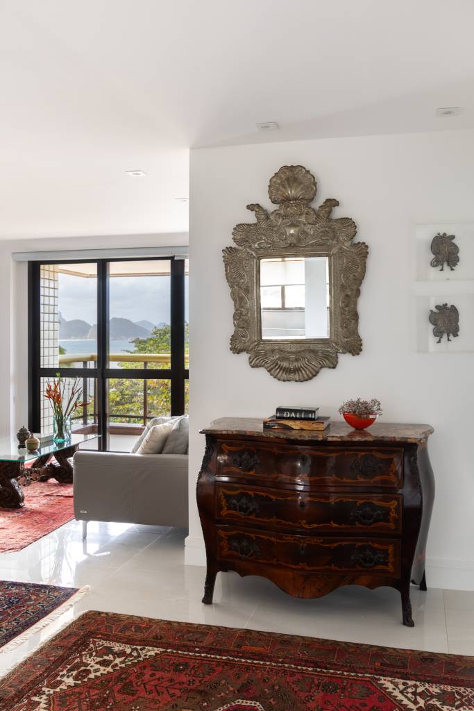 Apês de 65 m² são integrados e tornam-se lar espaçoso com bar e closet. Projeto de Vivian Reimers. Na foto, hall, espelho, móveis vintage.