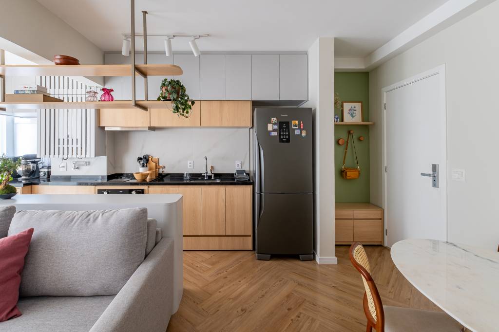 Marcenaria planejada é rack na sala e guarda-roupa no quarto neste apê de 39 m². Projeto de Bya Ribeiro Arquitetura e Thaís Viana. Na foto, sala integrada com cozinha.