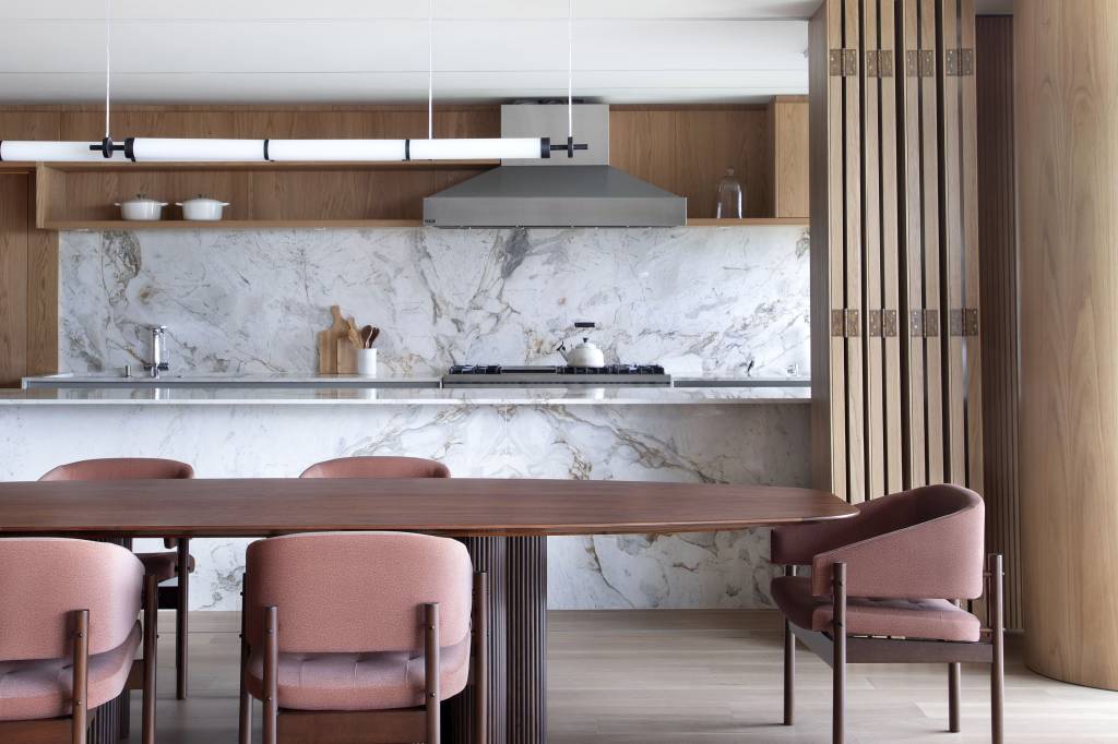 Painel de marcenaria articulado divide sala e cozinha em apartamento