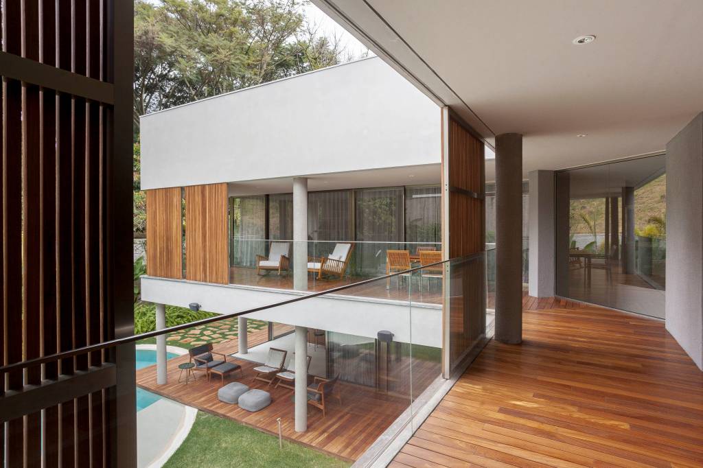 Piscina em forma de lago e suíte de 150 m² são destaque em casa. Projeto de DB Arquitetos.