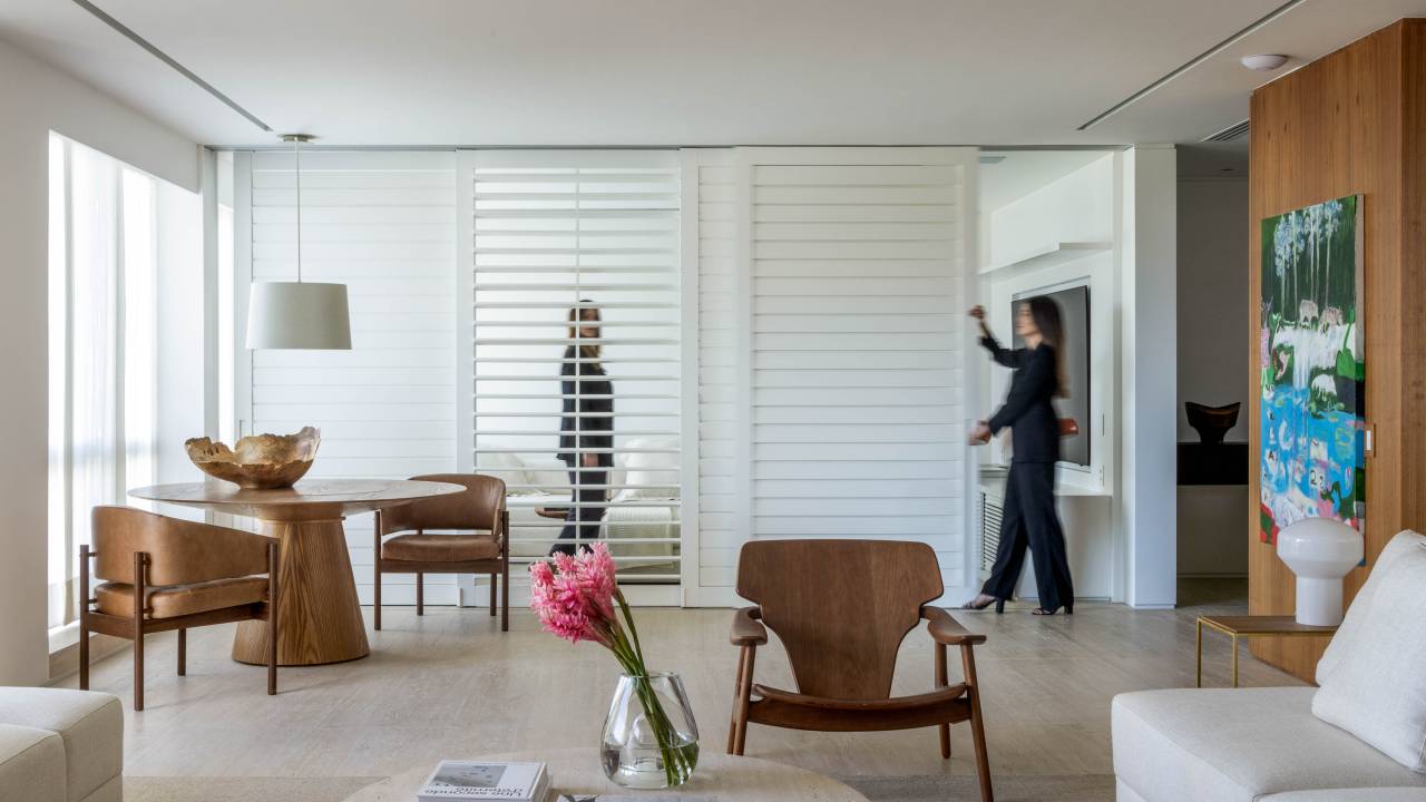 Portas de correr caribenhas com venezianas delimitam sala de TV em apê. Projeto de LessaZanetta. Na foto, sala de estar.