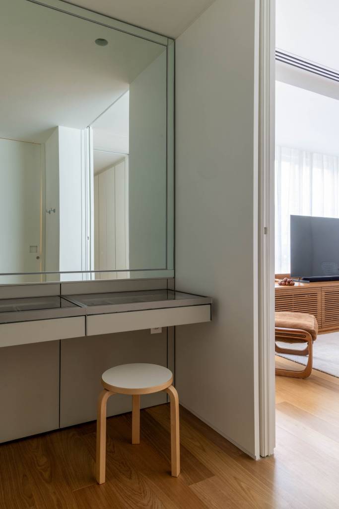 Portas de correr caribenhas com venezianas delimitam sala de TV em apê. Projeto de LessaZanetta. Na foto, penteadeira.