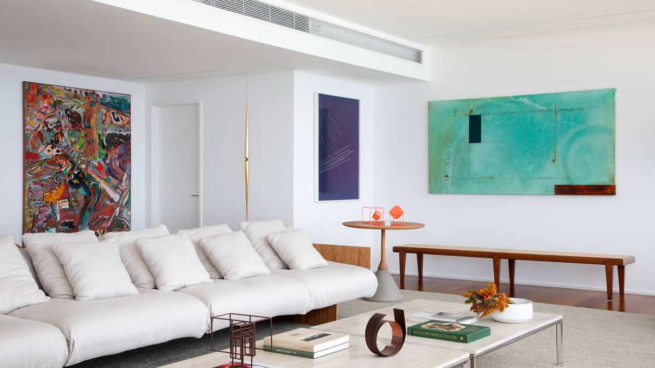 Área social ganha ares de galeria de arte neste apê de 220 m². Projeto de João Panaggio. Na foto, sala de estar com obras de arte como pontos de cor.